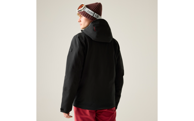 Personne vue de dos portant une veste à capuche noire, un pantalon rouge, un bonnet tricoté marron et des lunettes de ski sur le front sur un fond clair uni