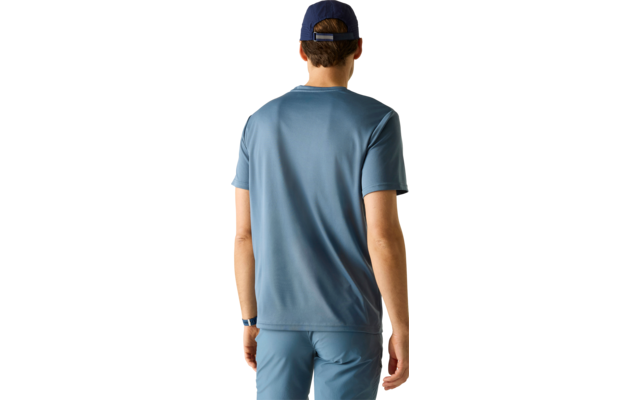 Person von hinten mit kurzem braunem Haar, dunkler Kappe, blauem T‑Shirt, blauer Hose und Armbanduhr vor hellem Hintergrund