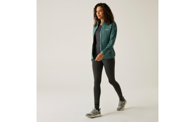 Frau geht in sportlicher Kleidung, graue Jogginghose und grüner Pullover
