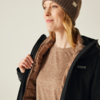 Frau mit brauner Mütze, braunem Pullover und schwarzer Jacke blickt nach rechts