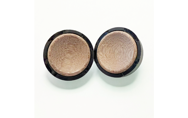 Zwei runde Dosen mit beigem, fein texturiertem Pulver und schwarzen Rändern auf weißem Hintergrund