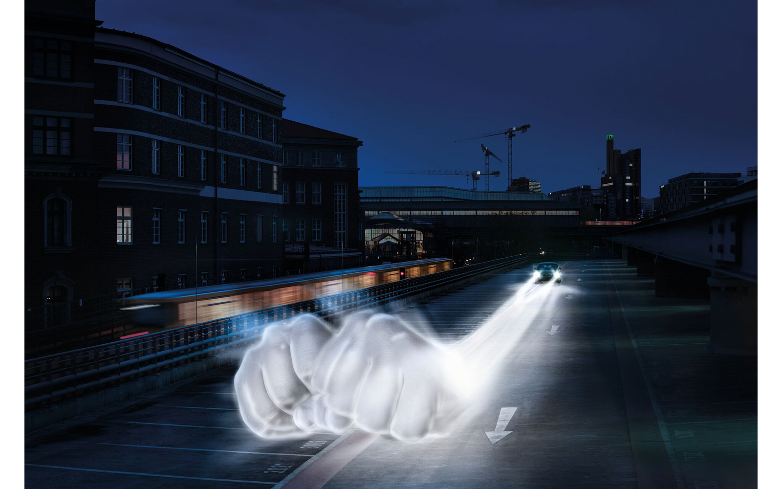 Stadsnachtbeeld: meerlaagse bakstenen gebouw links, hijskraan op de achtergrond, verhoogde weg met twee koplampen, lichtsporen links, transparante spookachtige vuistvormen op het wegdek, witte pijl op het asfalt