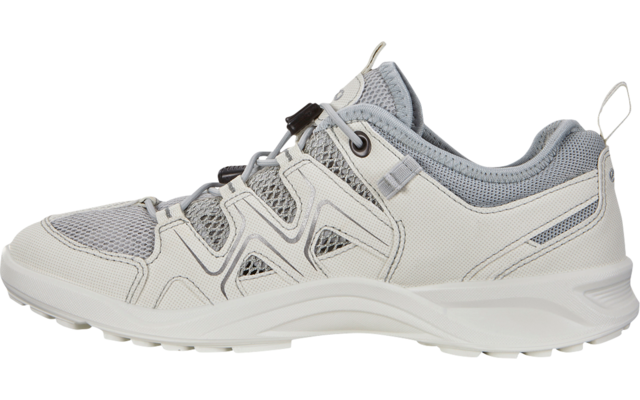 Vista lateral de un zapato bajo de color claro con malla y superposiciones sintéticas, cordón elástico con tope, presilla en el talón y suela blanca con dibujo