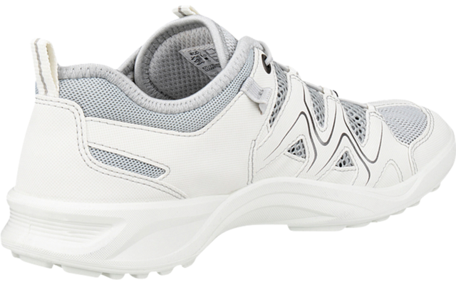 Zapatilla blanca y gris claro, vista lateral posterior izquierda, cordones y suela con relieve visibles