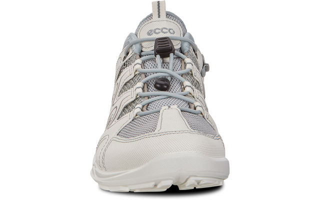 Vista frontal de un zapato con cordones gris claro y blanco con detalles de malla y cuero, cordones elásticos con cierres de plástico, suela con dibujo visible, texto 'ecco' en la lengüeta