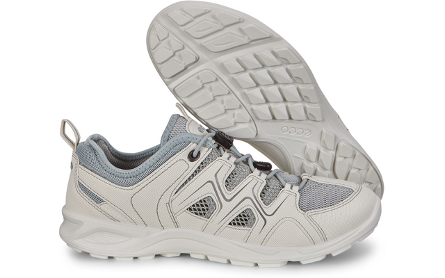 Dos zapatillas gris claro, una apoyada con la suela hacia arriba sobre la otra