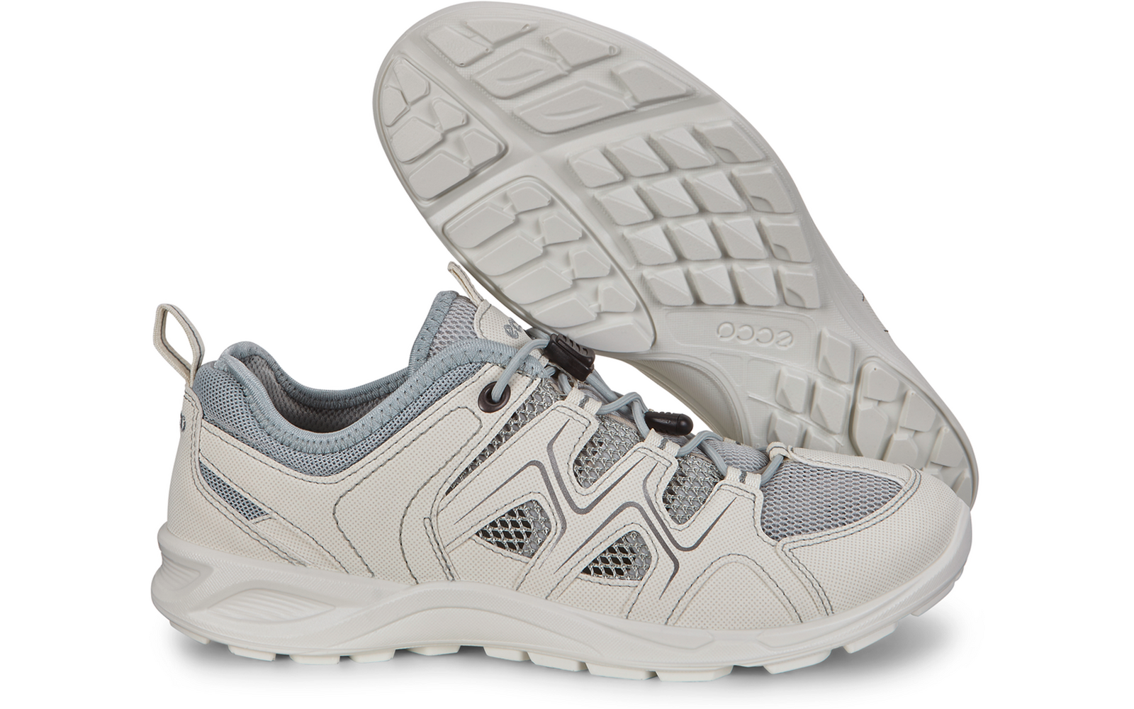 Dos zapatillas gris claro, una apoyada con la suela hacia arriba sobre la otra