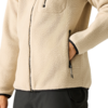 Teilansicht eines Oberkörpers in einer beige Fleecejacke mit Reißverschluss, Hand in einer Reißverschlusstasche; schwarze Hose sichtbar