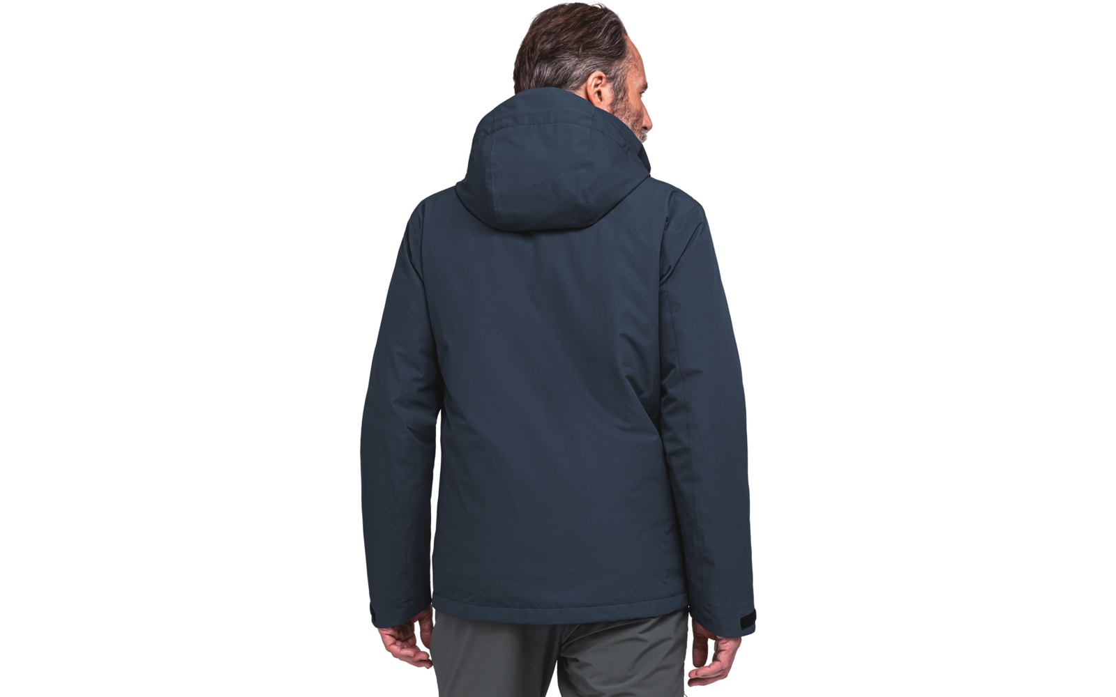 Vue de dos d'une personne debout portant une veste sombre à capuche et un pantalon gris, tête légèrement tournée vers la droite