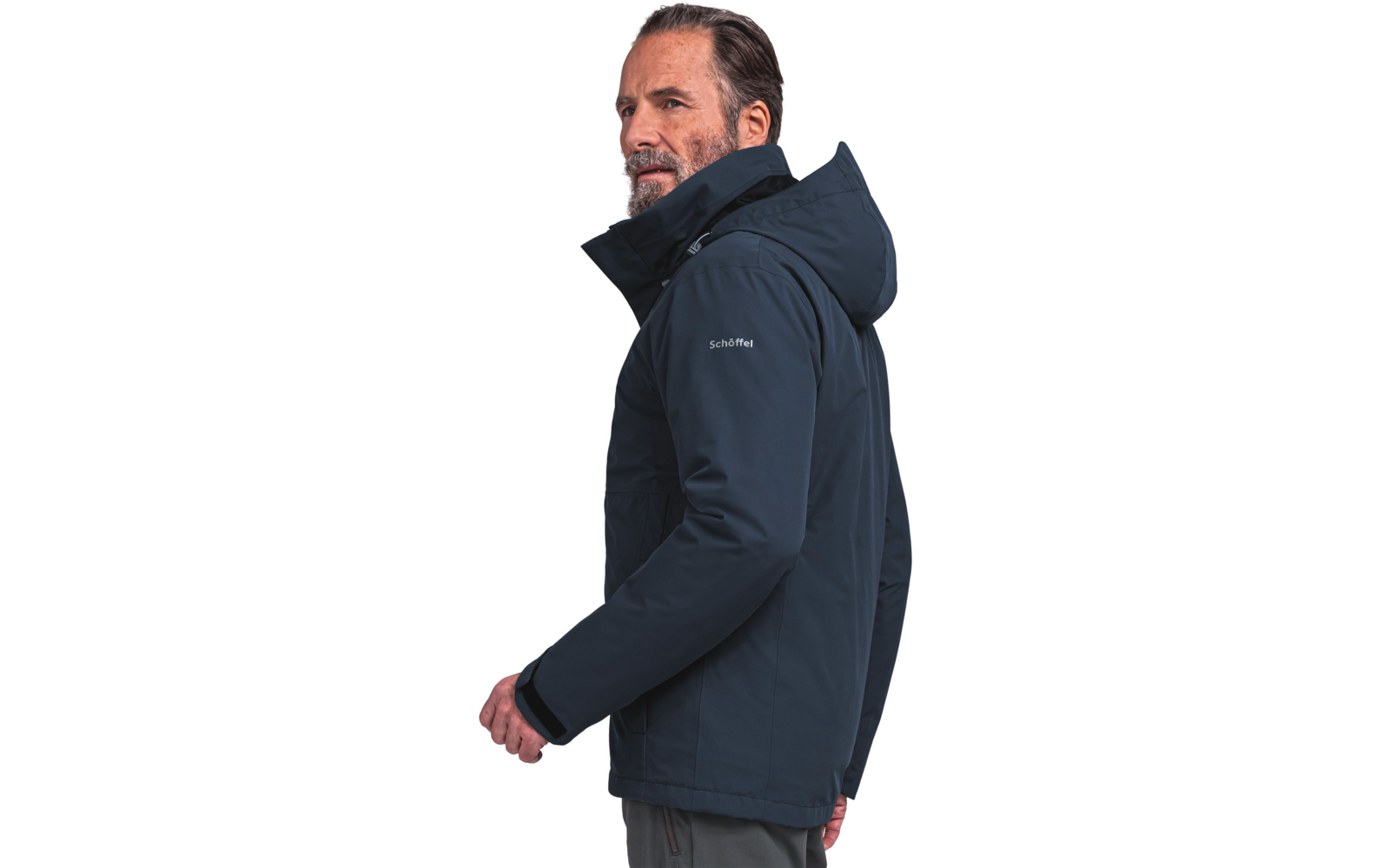 Vue de profil d'un homme adulte portant une veste bleu foncé à capuche, l'inscription "Schöffel" est visible sur la manche