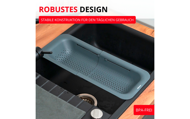 Passoire en silicone gris‑vert au‑dessus d'un évier de cuisine noir dans un plan de travail en bois, bonde en acier inoxydable visible, robinet à gauche, torchon plié et bandes de texte rouges 'ROBUSTES DESIGN' et 'BPA-FREI'
