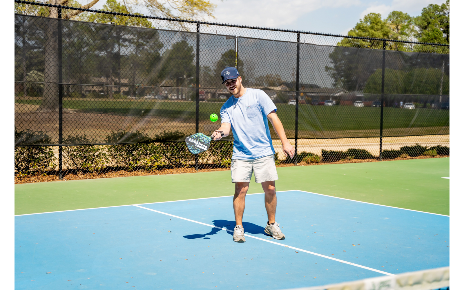 Person mit Tennisschläger auf Tennisplatz während Sonnenschein
