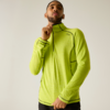 Personne portant un haut de sport vert néon à manches longues avec une courte fermeture éclair, tire la fermeture, debout devant un fond uni clair