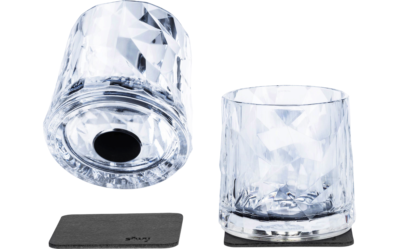 Two faceted clear drinking glasses, one upright on a black square coaster, the other upside down beside a second black square coaster on a white background