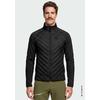 Homme avec moustache portant une veste matelassée noire zippée et un pantalon vert olive, debout devant un fond clair