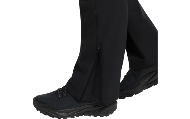 Schwarze Hose mit Reißverschluss am Beinende und schwarzen Sportschuhen