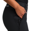 Hand steckt in der Hosentasche einer schwarzen Hose