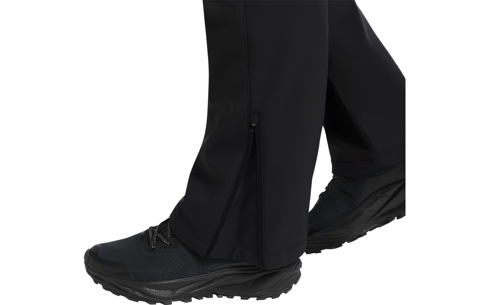 Schwarze Hose mit Reißverschluss am Beinende und schwarzen Sportschuhen