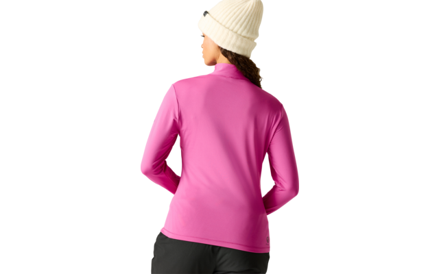Person von hinten mit dunklen lockigen Haaren, trägt pinkes Langarmshirt, schwarze Hose und weiße Strickmütze, einfarbiger hellgrauer Hintergrund