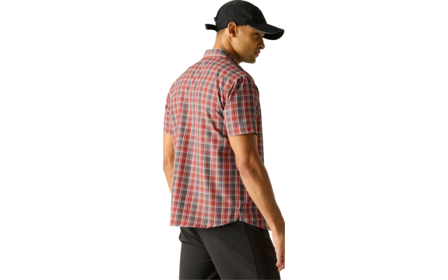 Mann von hinten mit schwarzer Kappe, rotem kariertem Kurzarmhemd und schwarzer Hose, schaut zur Seite vor hellem Hintergrund