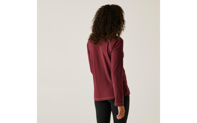 Frau mit lockigem Haar, die von hinten zu sehen ist, trägt ein rotes Langarmshirt und schwarze Hose
