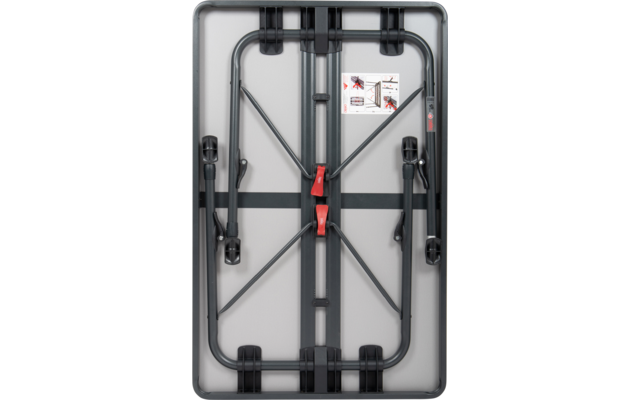 Gefalteter schwarzer Klapptisch mit zwei roten Sicherungen und einem weißen Aufkleber in der Mitte