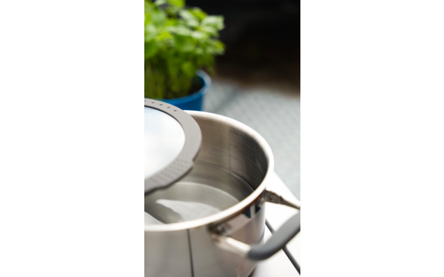 Ein Metalltopf mit Deckel, darauf liegt ein feinmaschiges Sieb