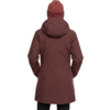 Persoon van achteren, draagt een bruin heuplang parka met capuchon en een roodbruine geribde muts; handen in de zijzakken, zwarte broek zichtbaar