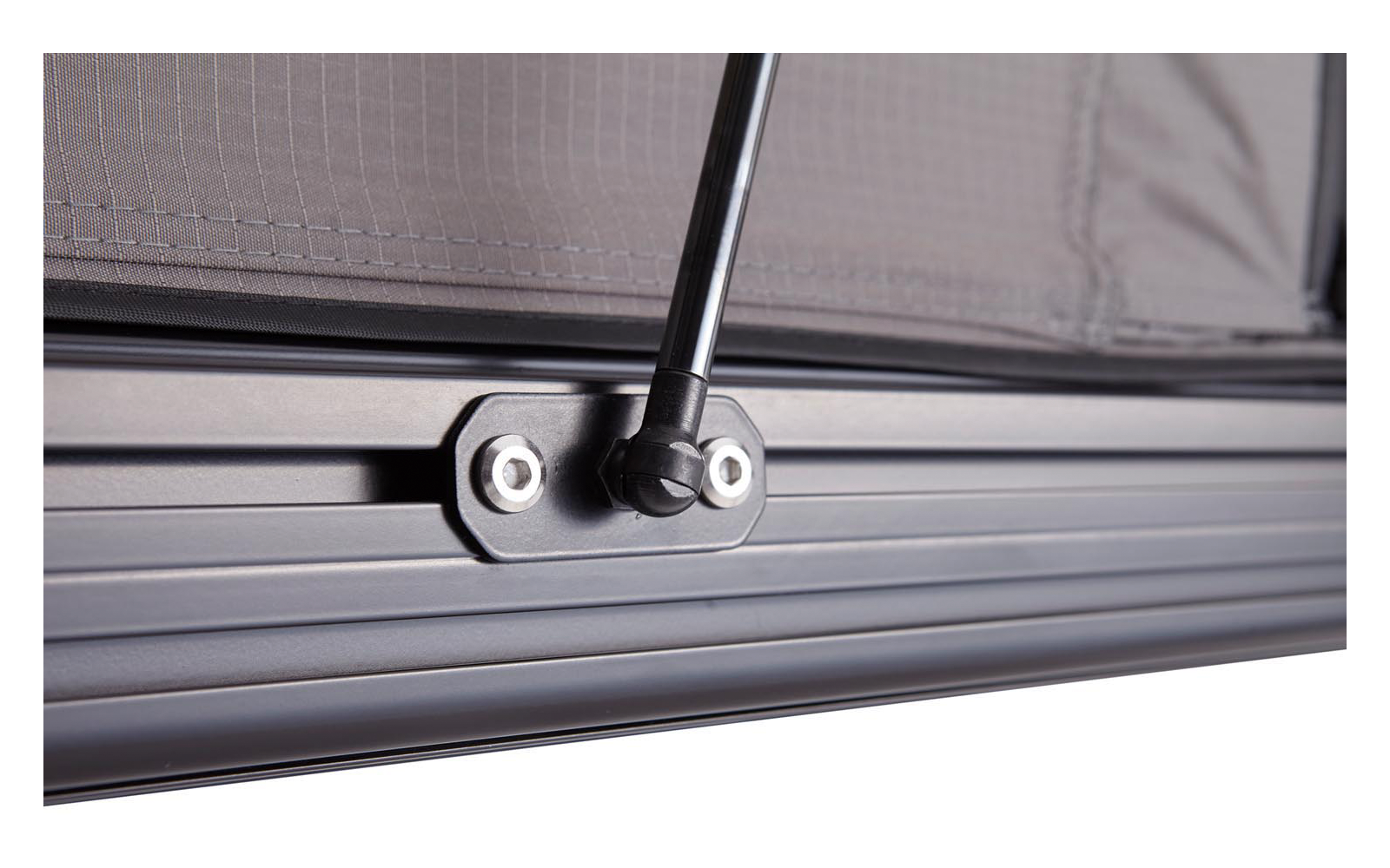 Nahaufnahme eines schwarzen Metallrahmens mit Rillen, einer schwarzen Stange mit Gelenk, befestigt mit sichtbaren Schrauben, und einem grauen Stoffnetz im Hintergrund