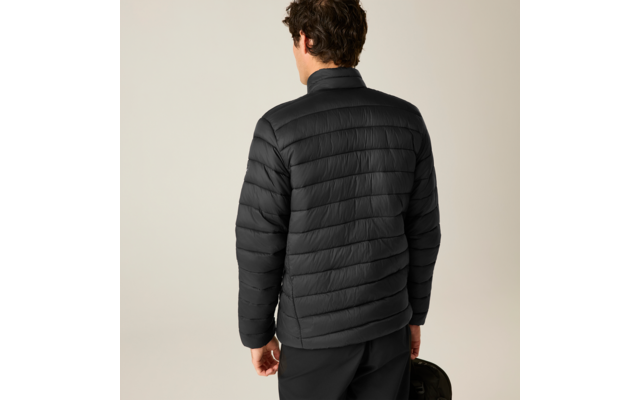 Rückansicht einer Person in schwarzer gesteppter Jacke und schwarzer Hose, hält eine schwarze Tasche in der rechten Hand; heller Hintergrund