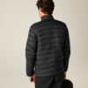 Rückansicht einer Person in schwarzer gesteppter Jacke und schwarzer Hose, hält eine schwarze Tasche in der rechten Hand; heller Hintergrund