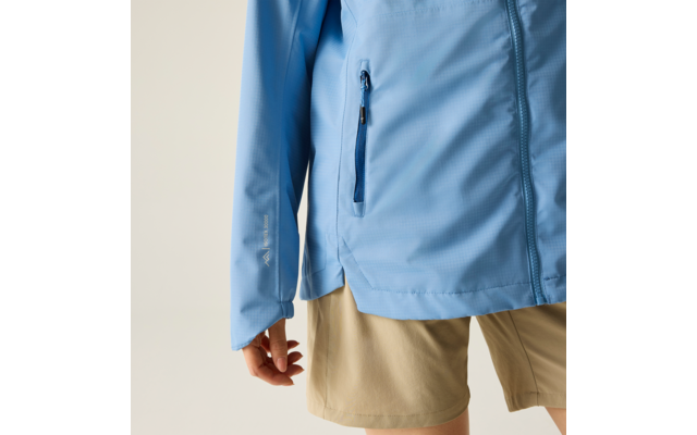 Unterer Torso einer Person mit hellblauer Jacke mit Reißverschlusstasche und beigen Shorts, linke Hand sichtbar