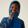 Kind draagt blauwe capuchonjas en lacht