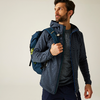 Mann mit Bart trägt einen blauen Rucksack und schaut nach rechts