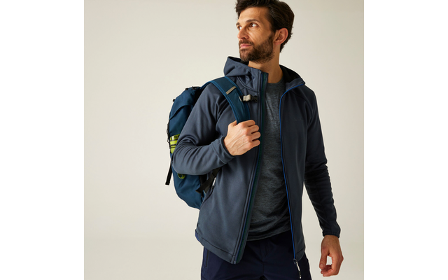 Mann mit Bart trägt einen blauen Rucksack und schaut nach rechts