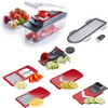 Several red and gray kitchen slicer and grater attachments, a transparent container with tomato slices, whole tomatoes, an onion and garlic, cucumber slices and spiralized zucchini