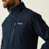 Oberkörper einer Person links im Bild; Bart und Teil des Gesichts sichtbar; dunkelblaue Jacke mit hohem Kragen, vertikalem Reißverschluss, Brusttasche und weißem 'Regatta Great Outdoors'-Logo