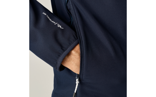 Hand steckt in Reißverschlusstasche einer dunkelblauen Jacke, weißer Reißverschluss und weißes Logo auf dem Ärmel