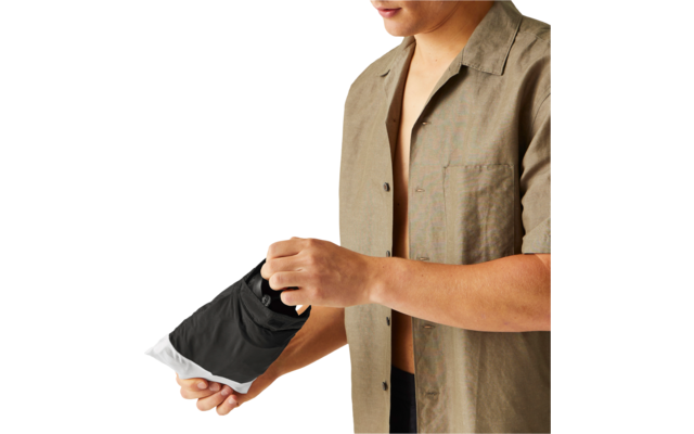 Oberkörper einer Person in offenem kurzärmeligem Hemd, die ein schwarz-weißes Objekt in beiden Händen hält