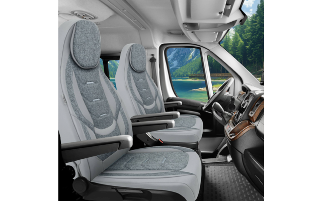 Innenraum eines Fahrzeugs mit zwei gepolsterten Vordersitzen, Armlehnen, Sicherheitsgurten, Lenkrad, Armaturenbrett und seitlicher Fensteransicht auf See, Berge und Wald