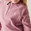 Nahaufnahme eines Mädchens in einem rosa Pullover mit Reißverschluss und weißem Logo auf der Brust