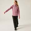 Frau in rosa Pullover und schwarzer Hose steht, eine Hand ausgestreckt