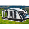 Black and white motorhome awning on a green lawn with mountains in the background