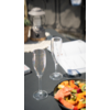 Wijnglas op een tafel met een bord salade en extra glazen op de achtergrond