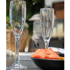 Twee lege champagneglazen naast een zwarte schaal met zalm
