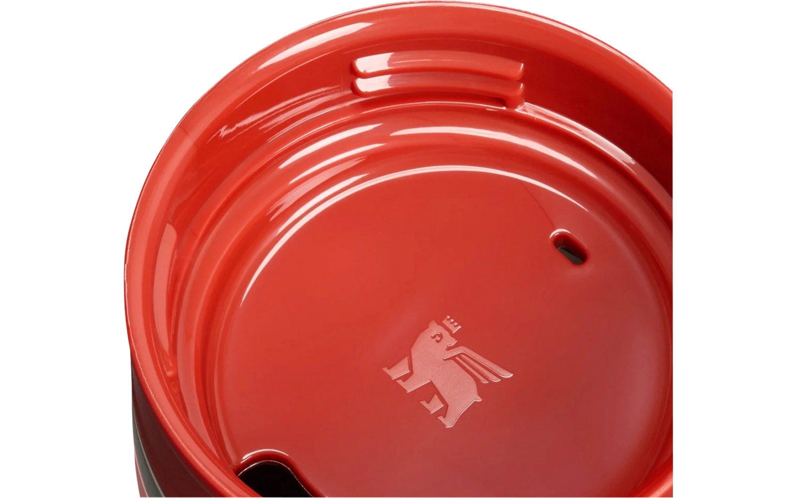 Nahaufnahme des oberen Teils eines rosa Reisebechers mit rotem Deckel, silbernem Metallrand, einer Trinköffnung, einer kleinen Lüftungsöffnung und einem eingeprägten Logo innen