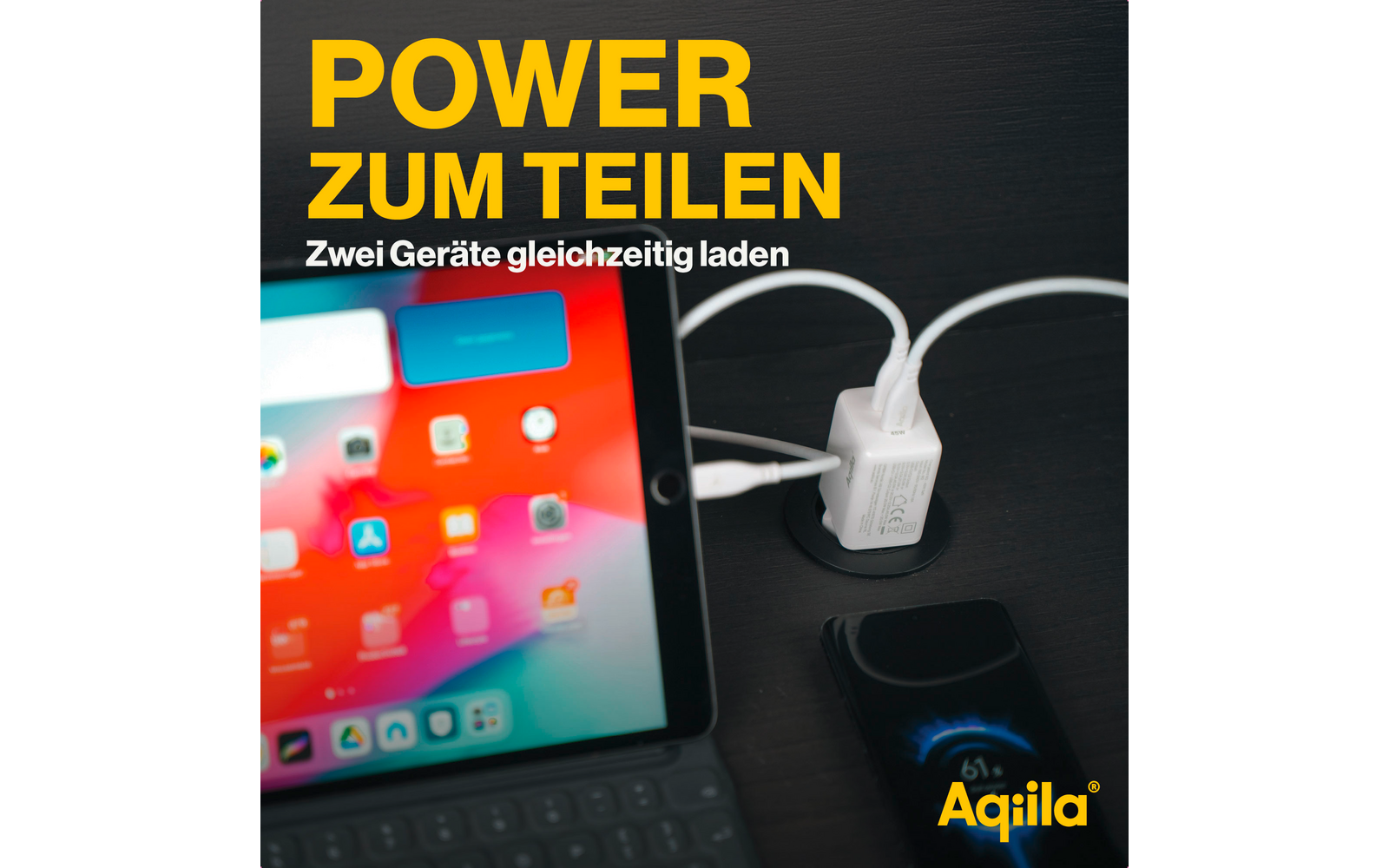 Tablet mit bunter App-Startseite neben zwei weißen Ladegeräten, die an einer Steckdose angeschlossen sind
