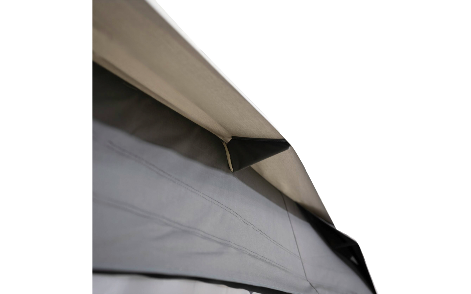 Nahaufnahme von übereinanderliegenden Stoffbahnen: hellbeige oberes Panel, graues unteres Panel mit sichtbaren Nähten und schwarzem dreieckigem Einsatz, weißer Hintergrund