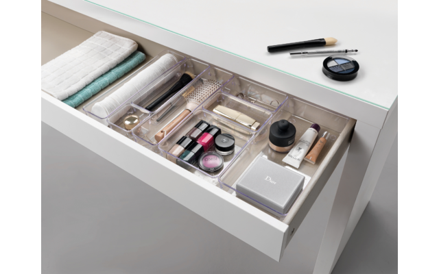 Offene Schublade mit verschiedenen Kosmetik- und Make-up-Produkten ordentlich sortiert