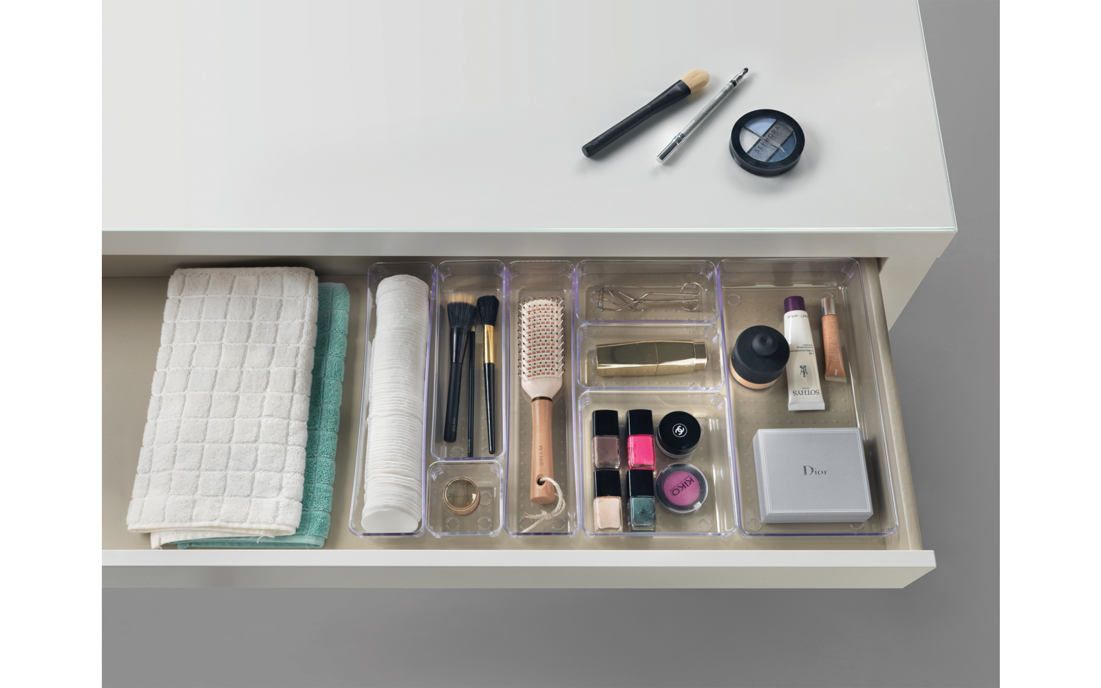 Offene Schublade mit Kosmetikartikeln, Wattestäbchen, Nagellack und Handtuch